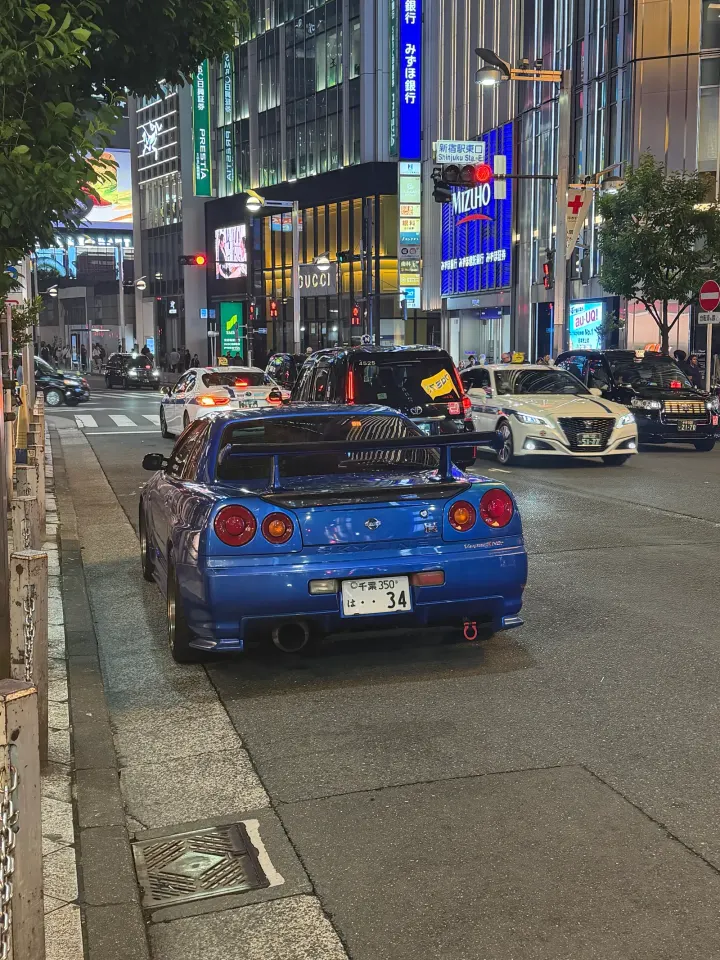 Blauer Sportwagen in Tokios Nacht