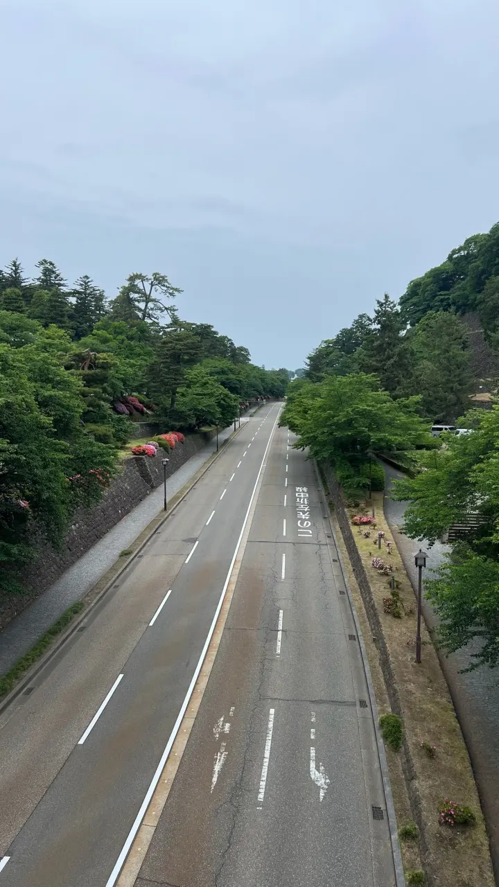 Regennasse Straße durch grüne Hügel, Kanazawa